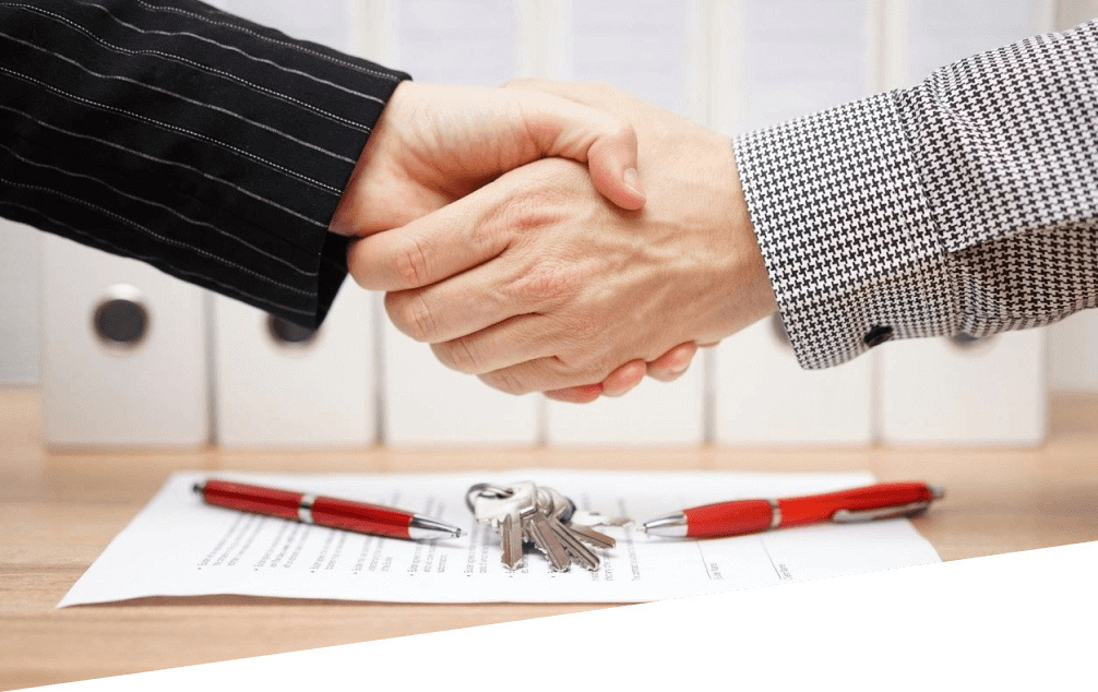 Two people shaking hands over a contract