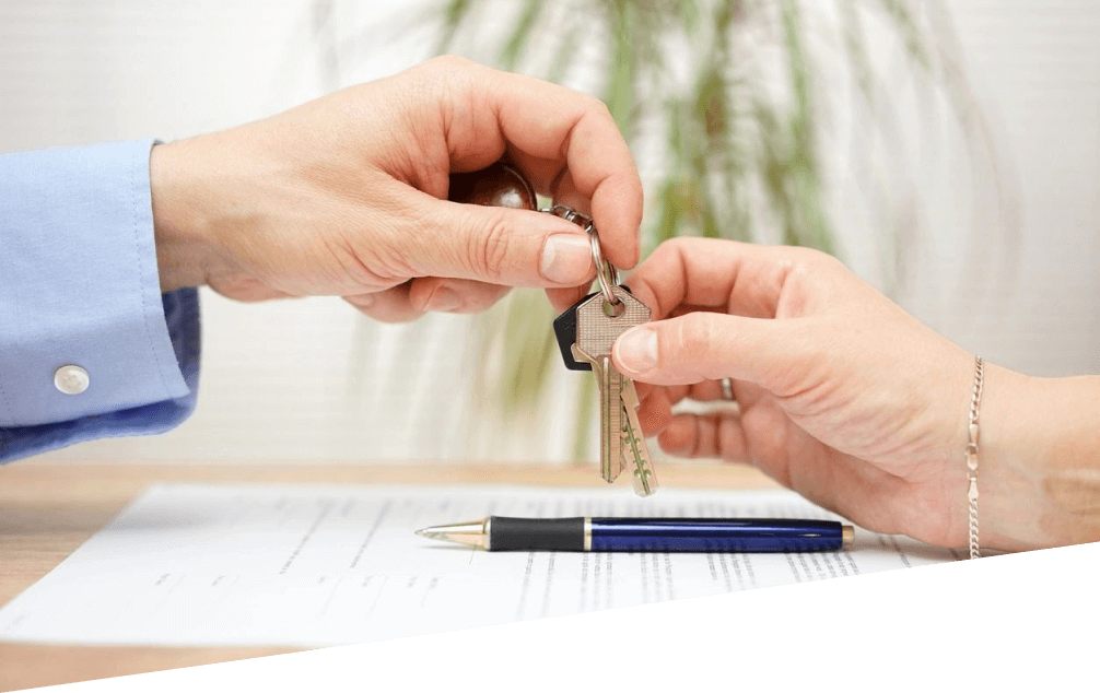 Two people holding keys to a house