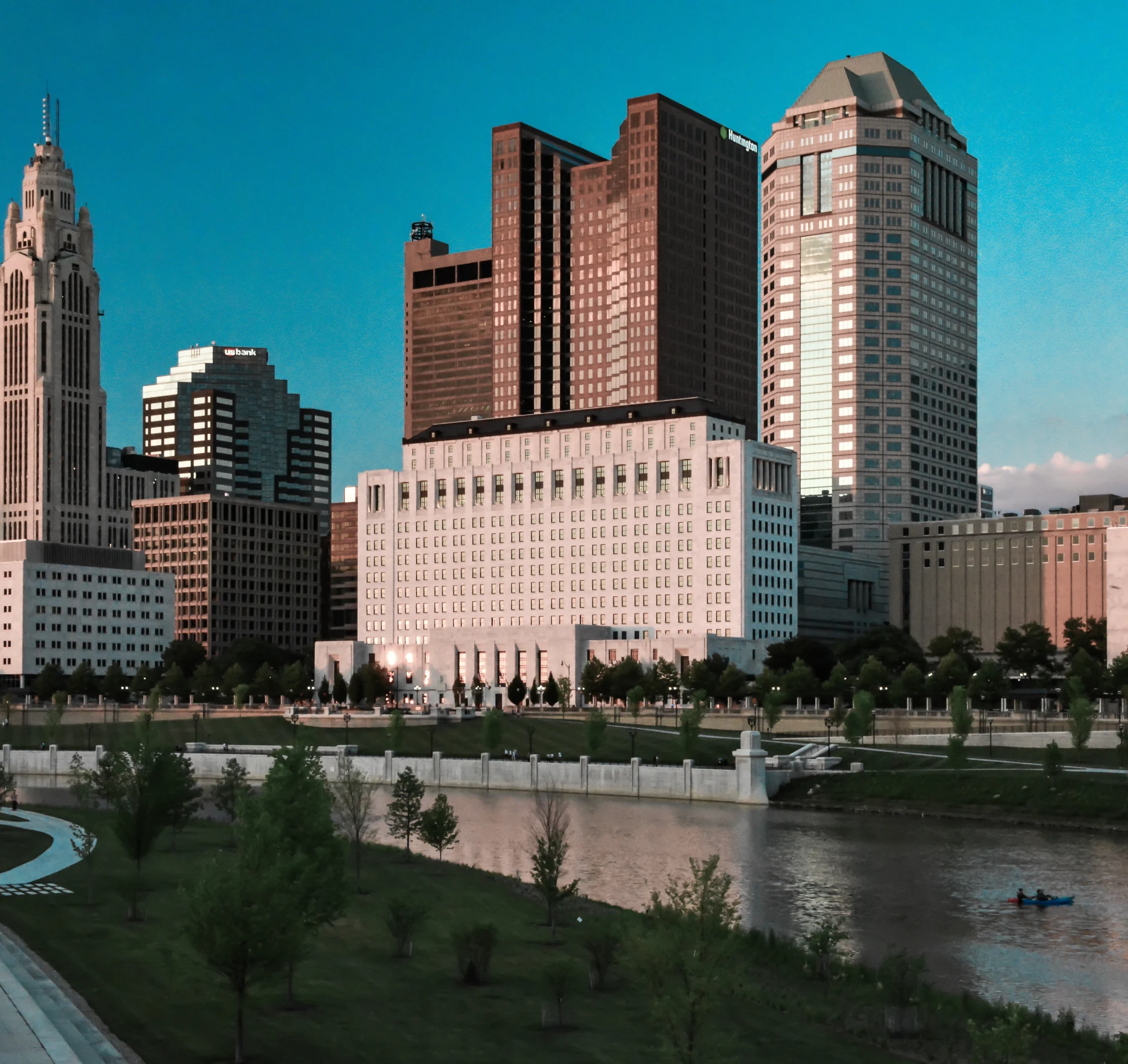 A city with many buildings and trees near the water